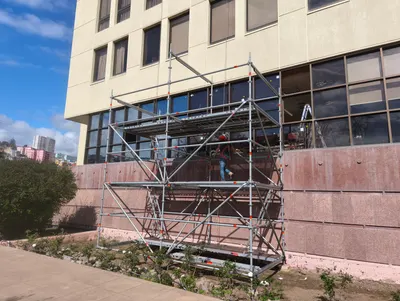 Andamio frente a la fachada vidriada de un edificio durante trabajos en sus ventanales