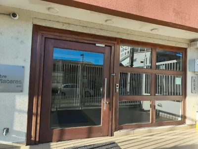 Puerta de acceso de madera con paños vidriados en la entrada de un edificio